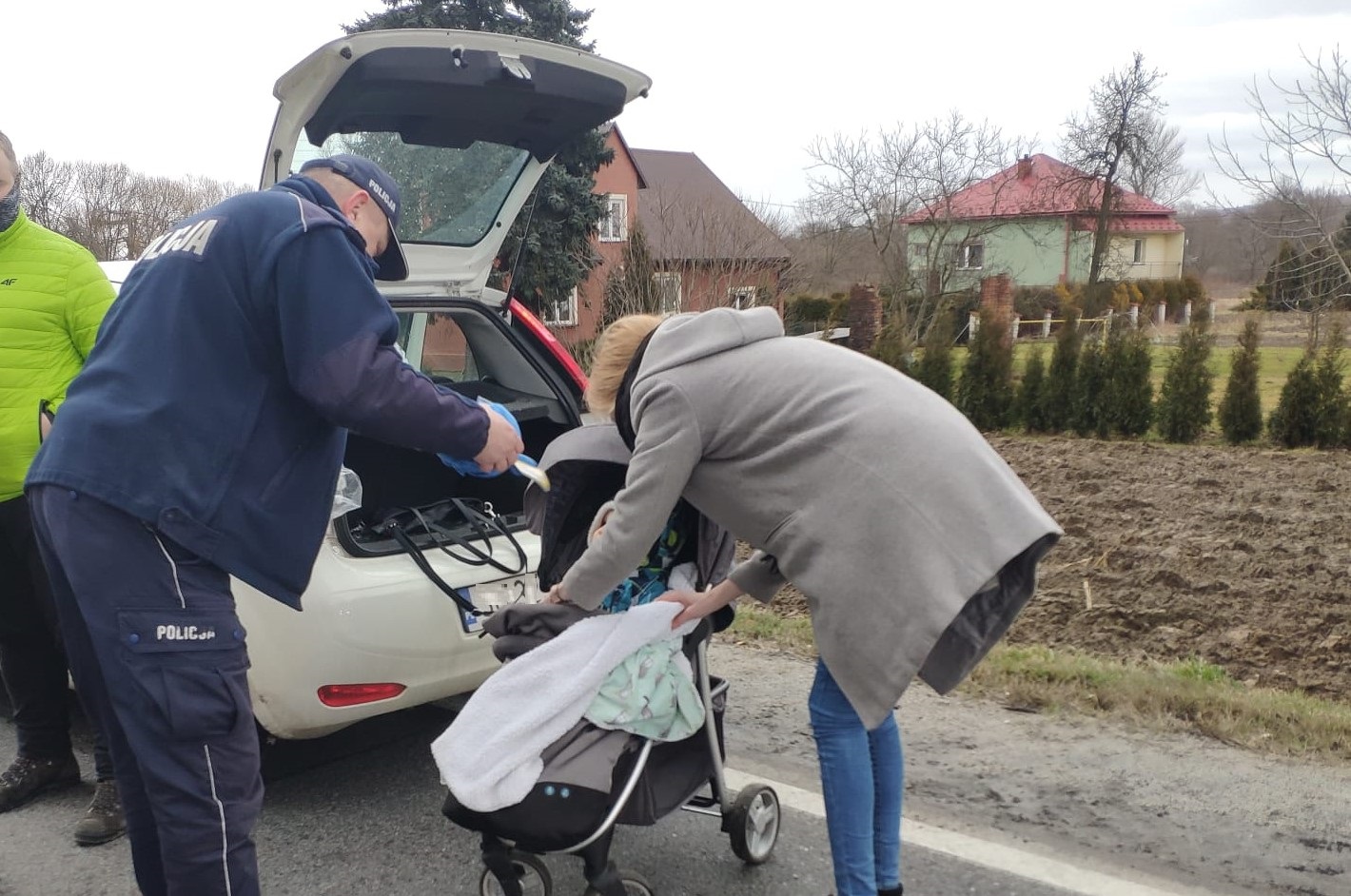 KPP Oswiecim. Policjant z zatora przekazuje maskotkę dziecku